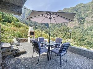 - une table avec des chaises et un parasol sur la terrasse dans l'établissement Mystic Mountain by Atlantic Holiday, à São Vicente