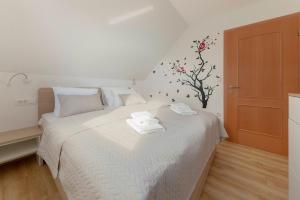 a bedroom with a white bed with towels on it at Apartments Nikolaj in Preddvor