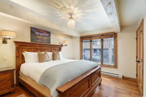 Un dormitorio con una cama grande y una ventana en Chateau Roaring Fork Unit 38, Condo with Private Deck, 4 Blocks from Downtown, en Aspen