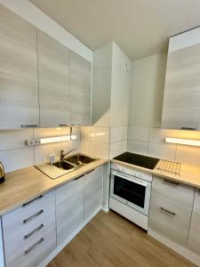 a kitchen with white cabinets and a sink at Viihtyisä tilava kaksio in Valkeakoski