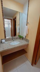 a bathroom with a sink and a mirror at Apartamentos Boulevard in Caldas Novas