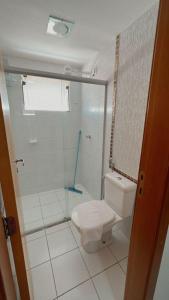 a bathroom with a toilet and a glass shower at Apartamentos Boulevard in Caldas Novas