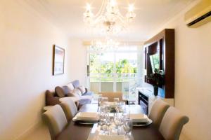 uma sala de jantar com uma mesa longa e um lustre em Jurerê In 4 dormitórios com ótima localização em Florianópolis