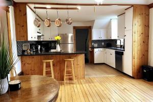 uma cozinha com um balcão de madeira e uma mesa em Rustic cabin-inspired residence. em Caledon