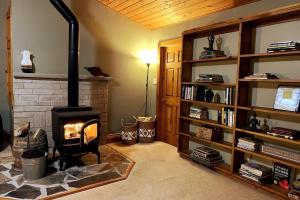 sala de estar con chimenea de ladrillo y chimenea en Rustic cabin-inspired residence., en Caledon
