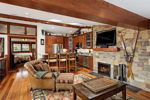 a living room with a fireplace and a tv at Fasching Haus Unit 5, Deluxe Condo with Great Natural Light & Amazing Location in Aspen