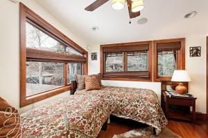 a bedroom with a bed and some windows at Fasching Haus Unit 5, Deluxe Condo with Great Natural Light & Amazing Location in Aspen