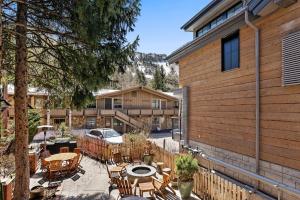 a patio with tables and chairs next to a building at Glory Hole Unit C, Remodeled condo w/ excellent location, wood-burning fireplace & new kitchen in Aspen