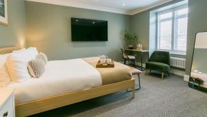a bedroom with a bed and a chair and a television at Mount Pleasant in Llanberis