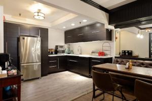 uma cozinha com um frigorífico de aço inoxidável e uma mesa em Independence Square 308, Top Floor Hotel Room with Ideal Downtown Location em Aspen