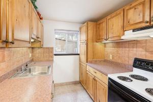 a kitchen with wooden cabinets and a sink and a stove at Silverglo Condominiums 104, Budget-Friendly Studio Close to Downtown, Full Kitchen, New Bathroom in Aspen