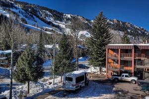 un camión estacionado frente a un edificio en la nieve en Silverglo Condominiums 104, Budget-Friendly Studio Close to Downtown, Full Kitchen, New Bathroom, en Aspen