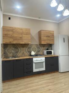 een keuken met houten kasten en een witte koelkast bij park home uralsk in Oral