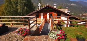 une petite maison avec des fleurs devant elle dans l'établissement Villa Meledrio, à Dimaro