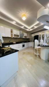 a large kitchen with white cabinets and a table at Maison Fathallah in Mahdia