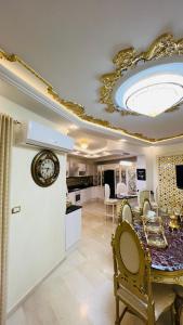 a kitchen and dining room with a clock on a ceiling at Maison Fathallah in Mahdia
