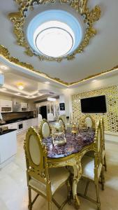 a dining room with a table with chairs and a ceiling at Maison Fathallah in Mahdia