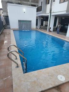 a large blue swimming pool in a building at Ikoyi/Banana Studio Room in Lagos