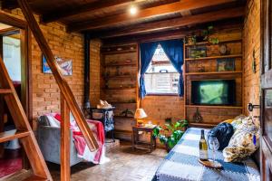 Habitación con sofá y TV. en Sitio Tahiupara en Gonçalves