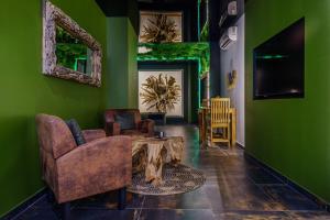 a living room with green walls and a table and chairs at Evasion Antillaise in Marseille