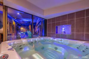 a jacuzzi tub in a room with a tv at Evasion Antillaise in Marseille