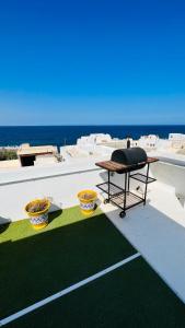a grill on the roof of a house with the ocean at Maison Fathallah in Mahdia