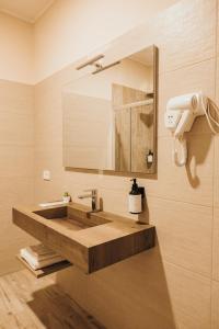 La salle de bains est pourvue d'un lavabo en bois et d'un miroir. dans l'établissement Affittacamere Mira Sinni, à Episcopia