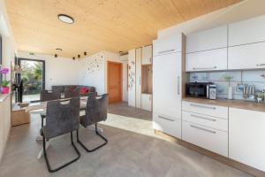 a kitchen with white cabinets and a table and chairs at Apartments Nikolaj in Preddvor