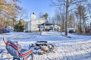 una casa con una hoguera en la nieve en New Hampshire Home with Private Beach, Dock and Rafts!, en Barnstead