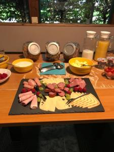 una tabla de cortar con carne y queso sobre una mesa en Die Radler-Scheune Finsterbergen, en Friedrichroda