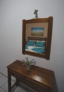 a mirror on a wall above a wooden table at Athena Kythera in Dhiakofti