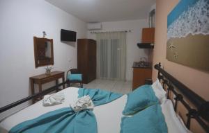 a bedroom with a bed with blue sheets at Athena Kythera in Dhiakofti
