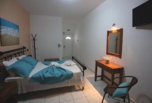a bedroom with a bed and a table and a mirror at Athena Kythera in Dhiakofti