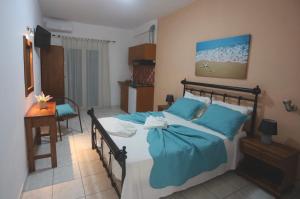 a bedroom with a bed with blue sheets and a desk at Athena Kythera in Dhiakofti