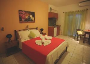 a bedroom with a red bed with a bow on it at Athena Kythera in Dhiakofti