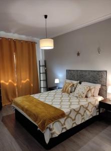 a bedroom with a large bed in a room at A Casa da Nocas- Quarto Yellow in Setúbal