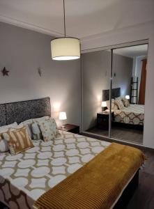 a bedroom with a large bed and a large mirror at A Casa da Nocas- Quarto Yellow in Setúbal