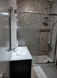 a bathroom with a sink and a shower at A Casa da Nocas- Quarto Yellow in Setúbal +5 photos