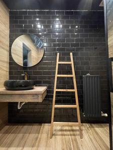 baño con escalera de madera y espejo en Casa Rural Camino de Hierro I y II, en La Fregeneda