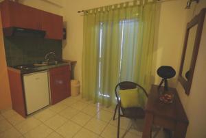 a kitchen with a sink and a table with a chair at Athena Kythera in Dhiakofti