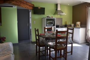 eine Küche mit einem Tisch und Stühlen im Zimmer in der Unterkunft Gîte le Grenier in Murviel