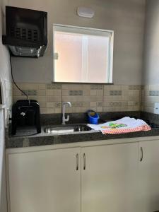 a kitchen counter with a sink and a microwave at Pousada Sete Estrelas do Mar in Ilhéus +16 photos