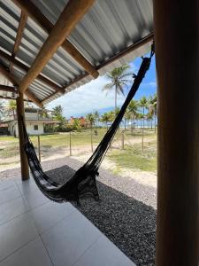 a hammock in a porch with a view of the ocean at Pousada Sete Estrelas do Mar in Ilhéus +17 photos