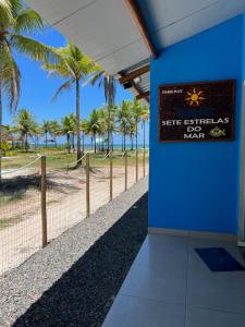 伊列烏斯的住宿－FLATS SETE ESTRELAS DO MAR，棕榈树围栏旁边的蓝色墙