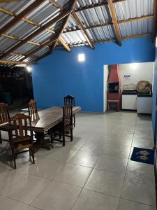 a dining room with a table and chairs and a blue wall at FLATS SETE ESTRELAS DO MAR in Ilhéus