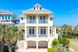 a large white house with palm trees in front of it at New Beachcombers at Luxurious Cinnamon Cove with Pool in Palm Coast