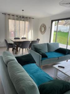 a living room with a couch and a table at Maison Bijou 3 chambres à 10min de DisneyLand Paris in Chalifert