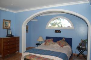 a blue bedroom with a bed and an arched window at Luxury Villa with Pool Sea and Mountain Views in Puerto de la Cruz in La Orotava