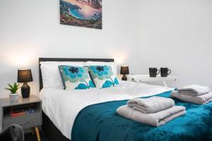 1 dormitorio con 1 cama con toallas en *Cosy home with parking for you* en Derby