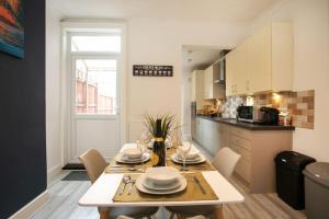 comedor y cocina con mesa y sillas en *Cosy home with parking for you*, en Derby